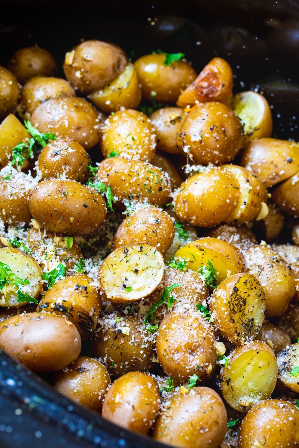 Potatoes in crock pot sprinkled with parsley.