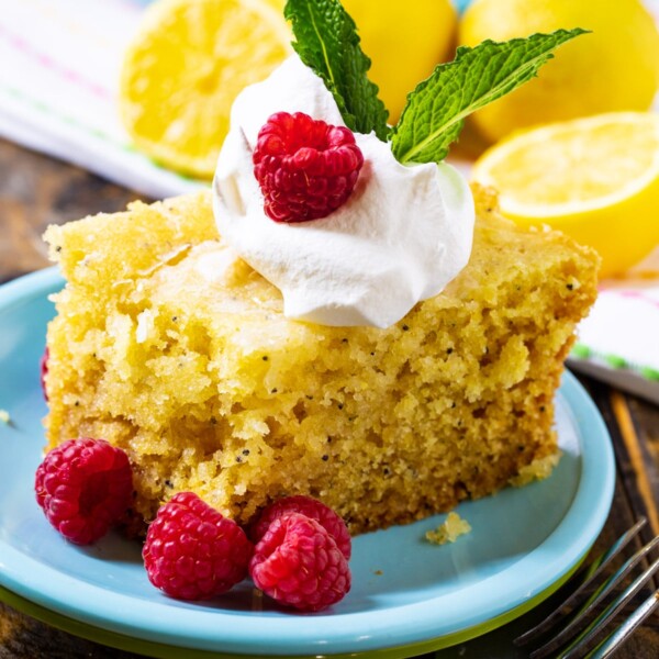 Slice of Slow Cooker Lemon Cake with fresh raspberries.