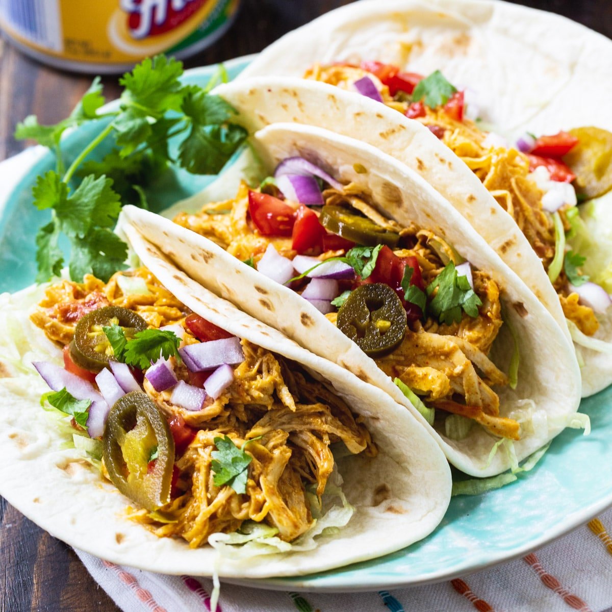 Slow Cooker Nacho Chicken in soft shell tacos.