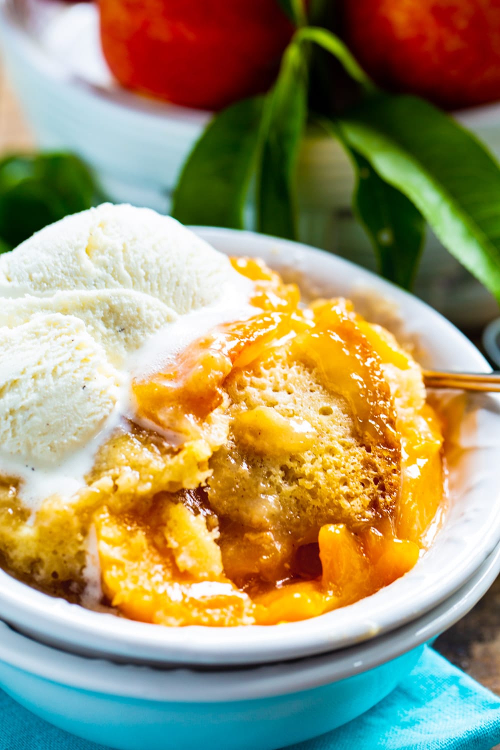 Slow Cooker Peach Cobbler topped with ice cream.