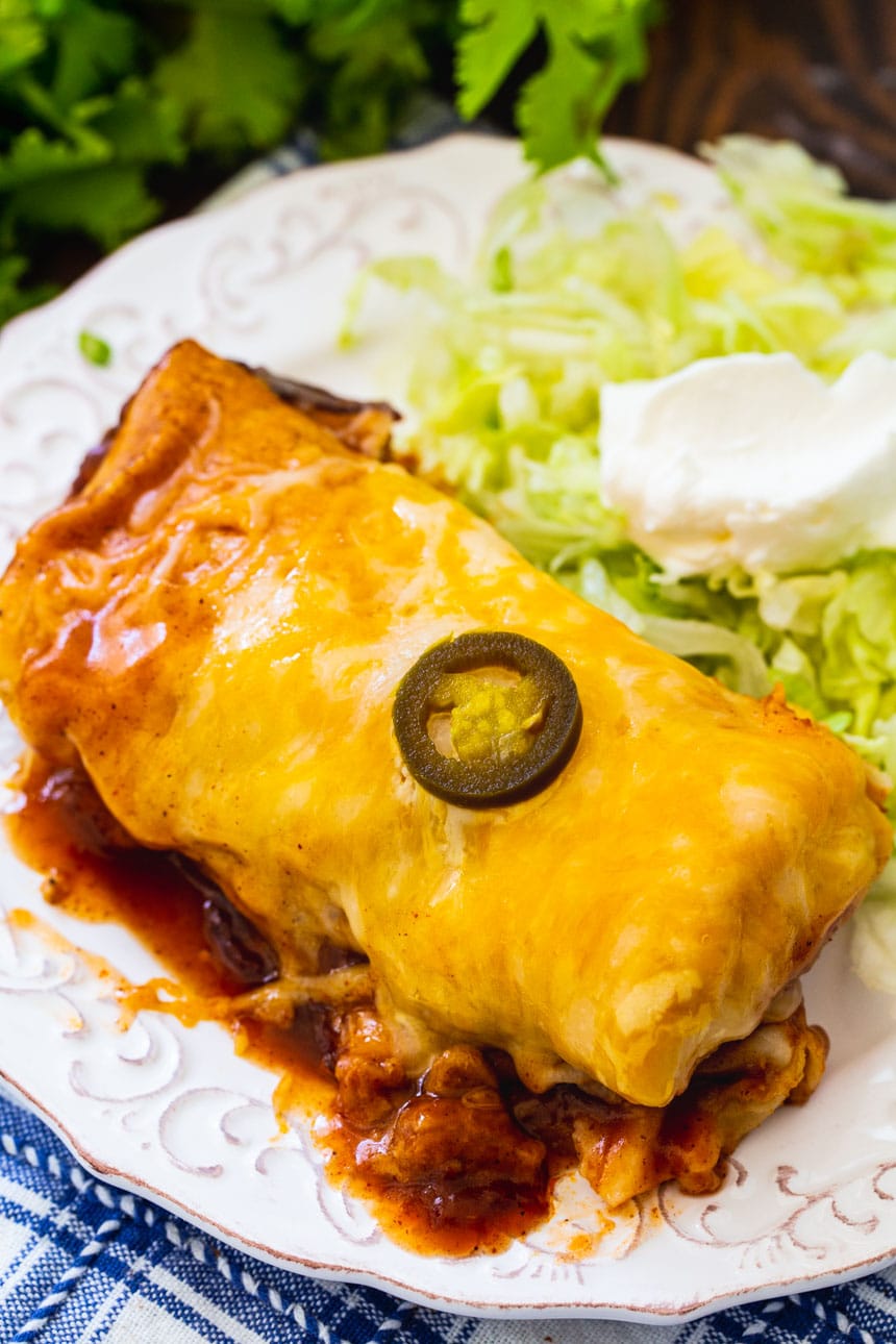 Slow Cooker Smothered Burrito on a plate with shredded iceberg lettuce