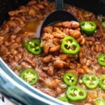 Spicy Pinto Beans in a crock pot with jalapenos on top