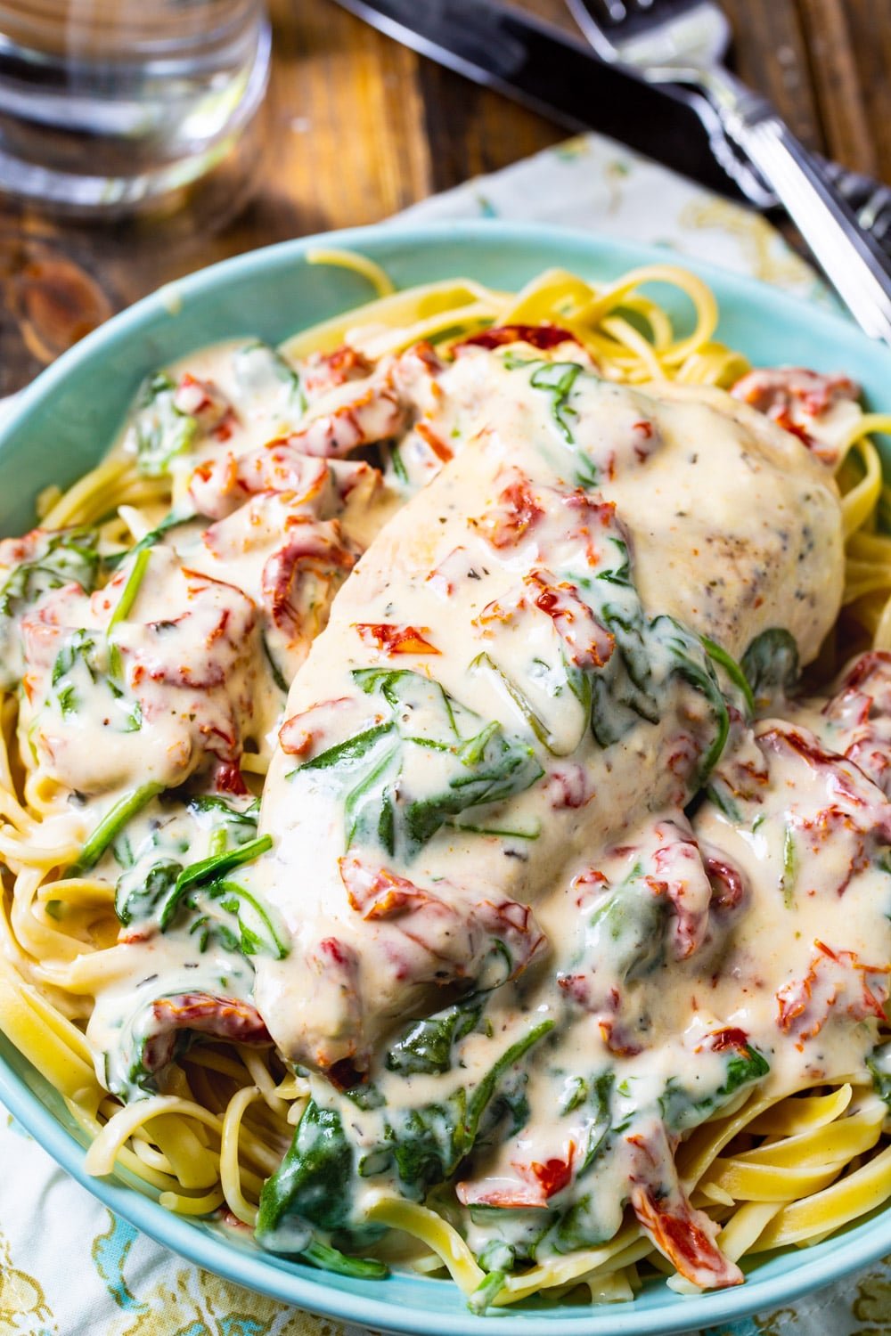 Slow Cooker Creamy Tuscan Chicken over pasta.