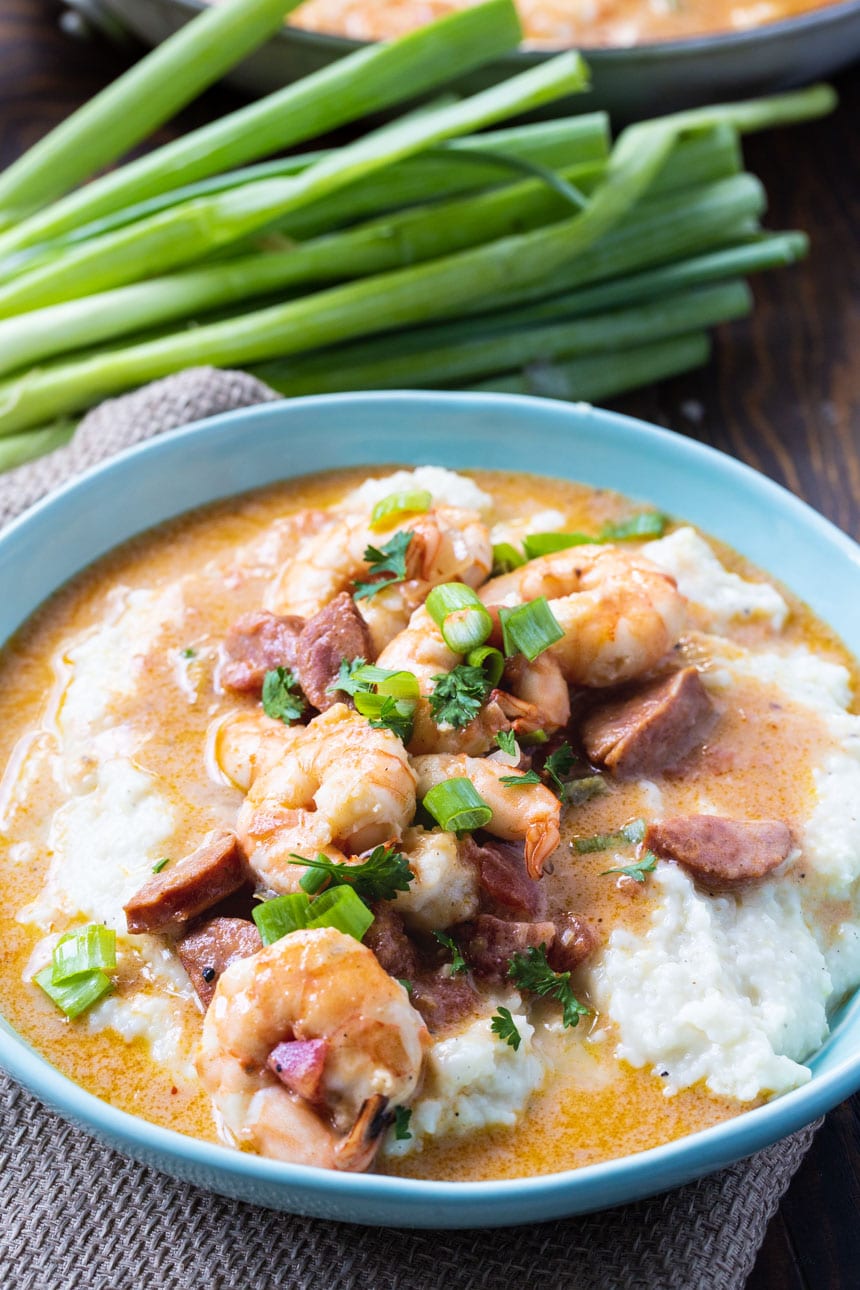 Smothered Shrimp and Parmesan Grits in a bowl with green onions.