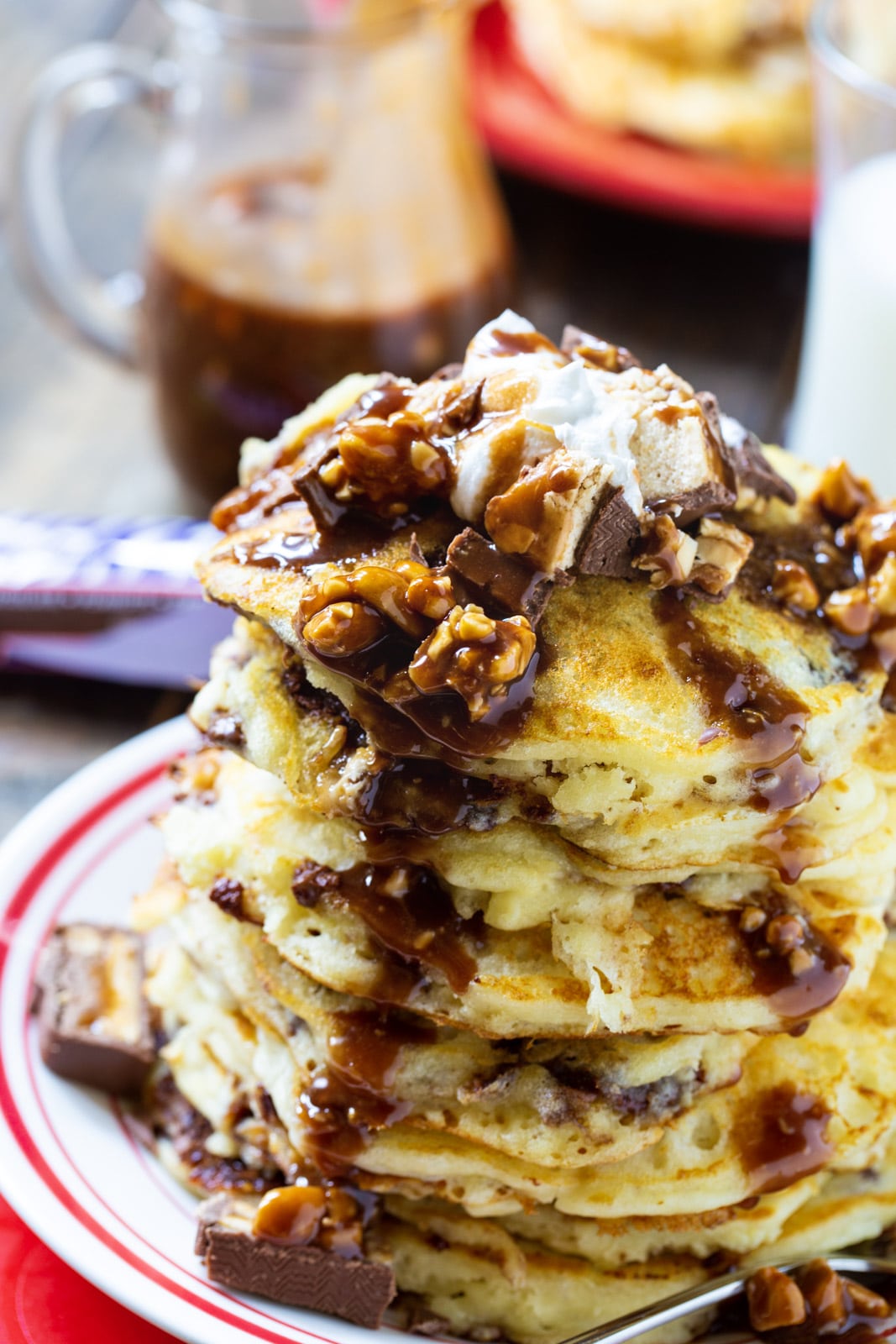 Stack of pancakes topped with snickers syrup.