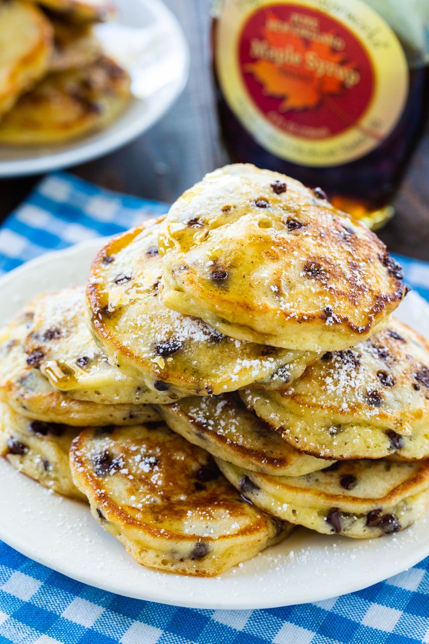 Sour Cream Pancakes on a plate with maple syrup in background.