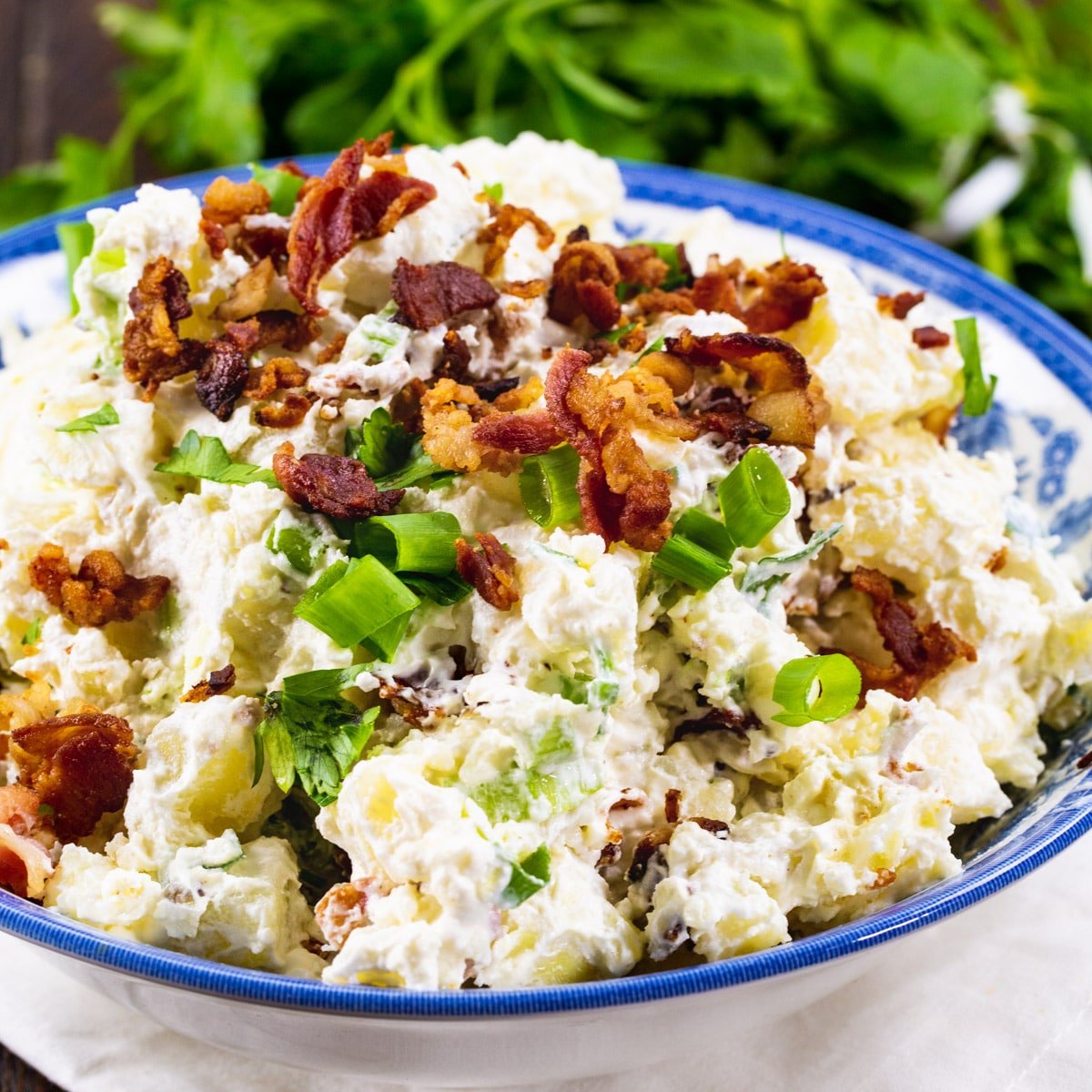 Sour Cream and Bacon Potato Salad in a blue and white bowl.