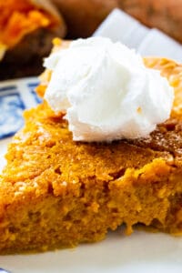Slice of Southern Sweet Potato Pie topped with whipped cream.