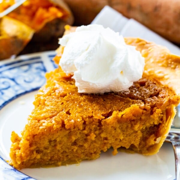 Slice of Southern Sweet Potato Pie topped with whipped cream.