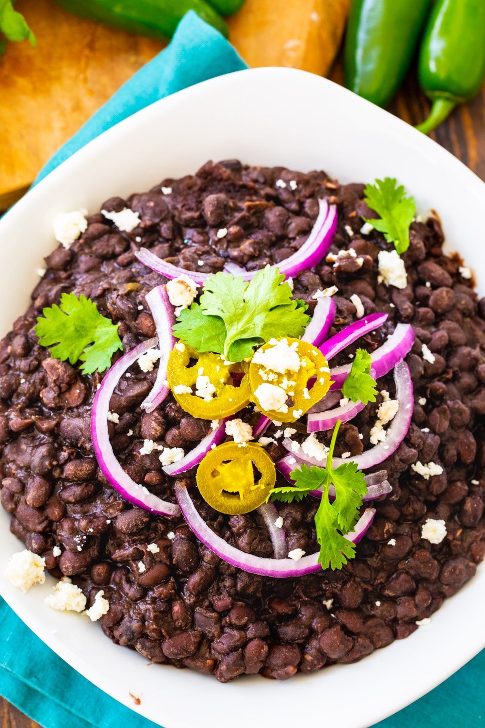 Overhead of Black Beans topped with jalapenos, cilantro and red onion.