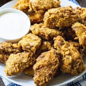 Spicy Fried Chicken Wings on a plate with bowl of dressing.