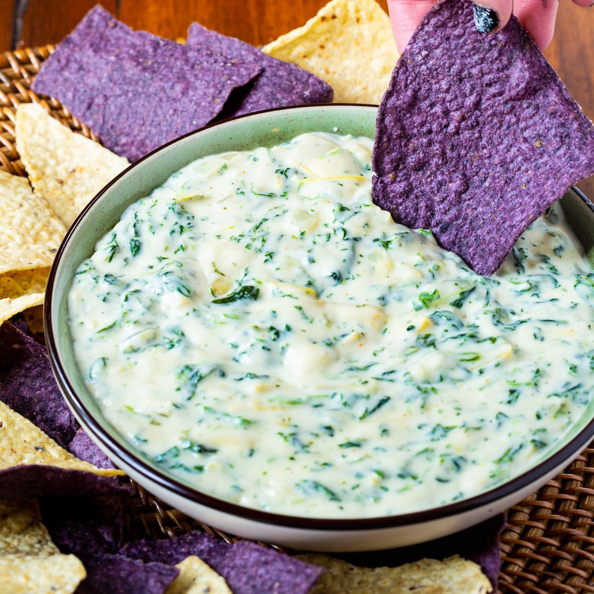Spinach Artichoke Dip in a bowl with tortilla chips.