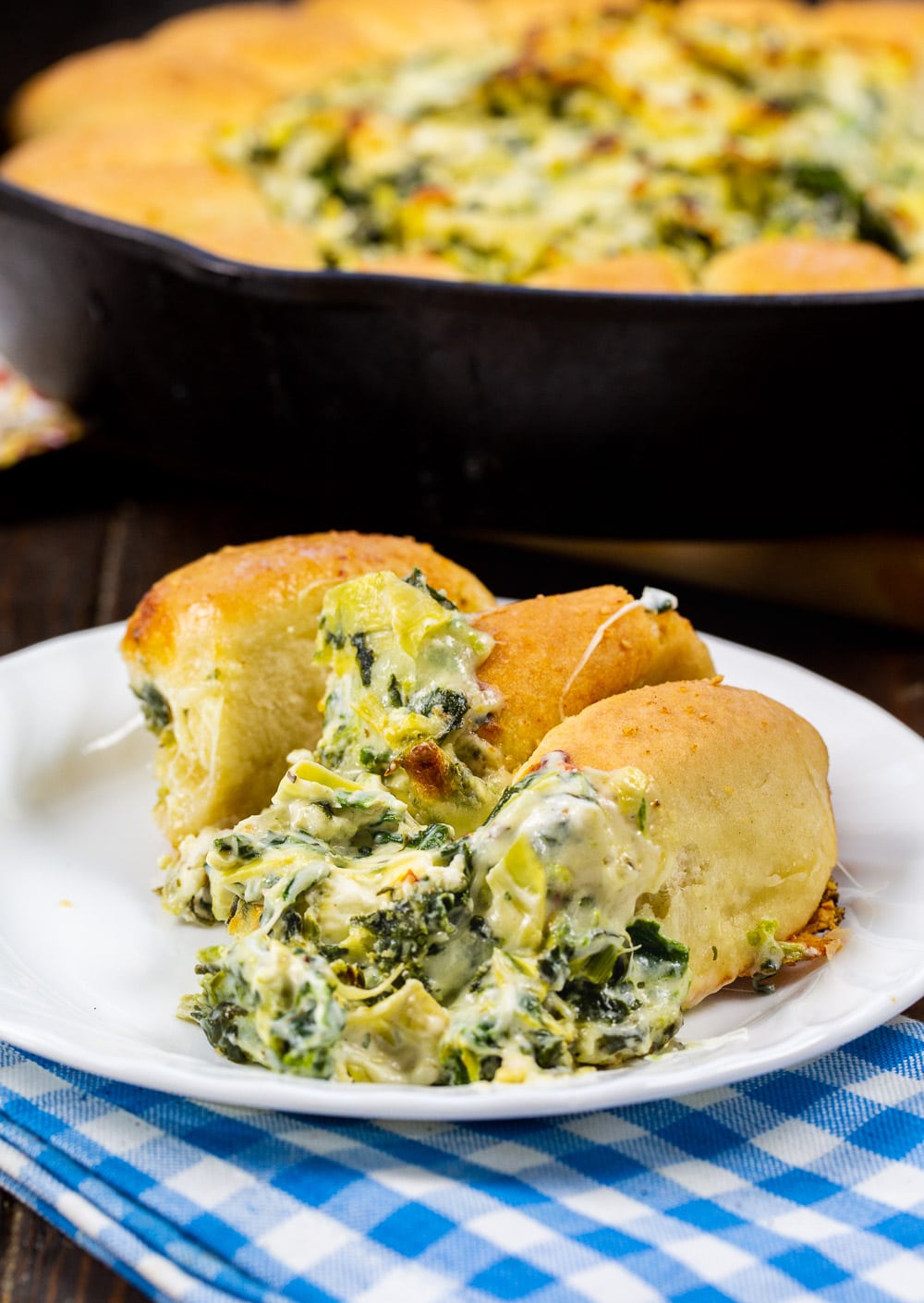 Rolls with Spinach Artichoke Dip on a plate.