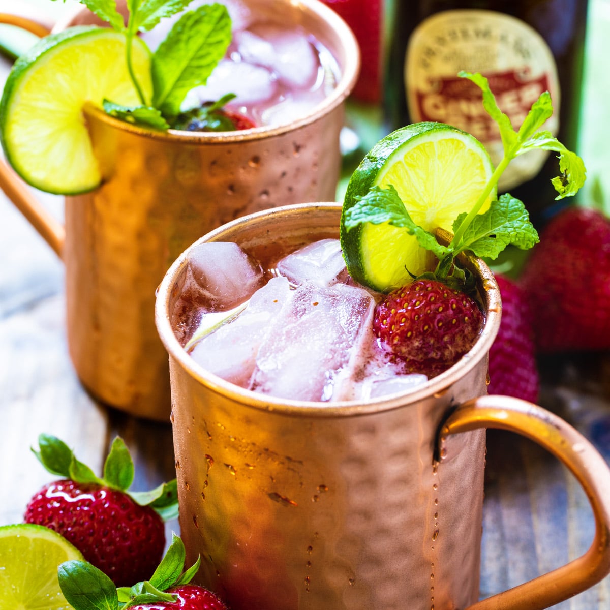 Strawberry Moscow Mule in copper cup with lime and mint.