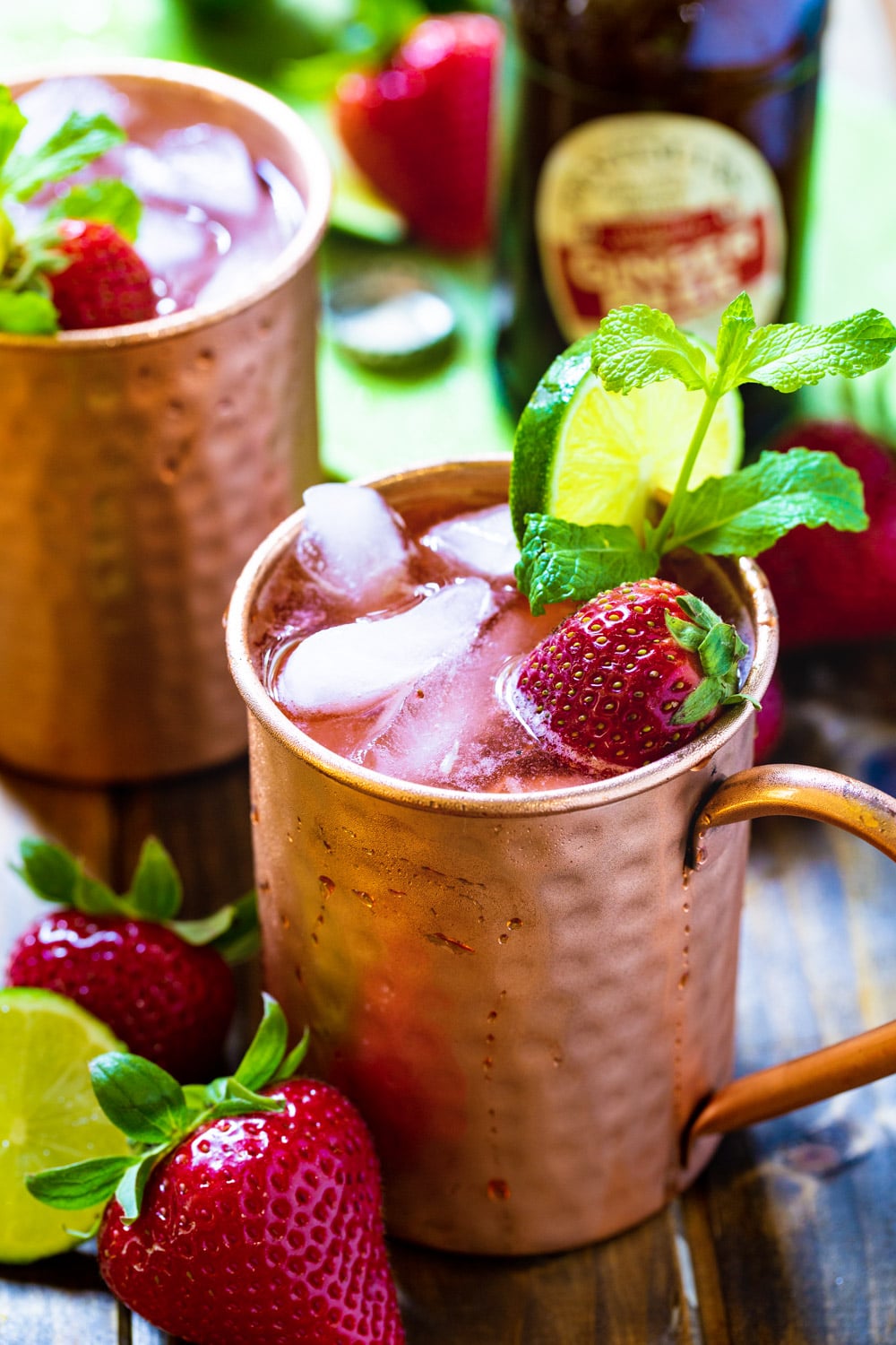 Two Strawberry Moscow Mules with mint and fresh strawberries.