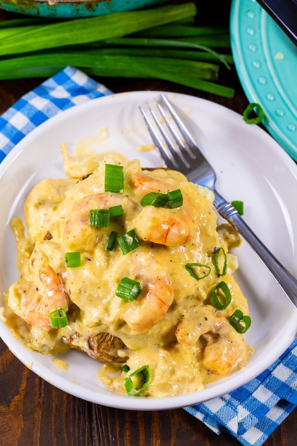 Double Stuffed Potatoes with Cheesy Seafood Sauce on plate with fork.