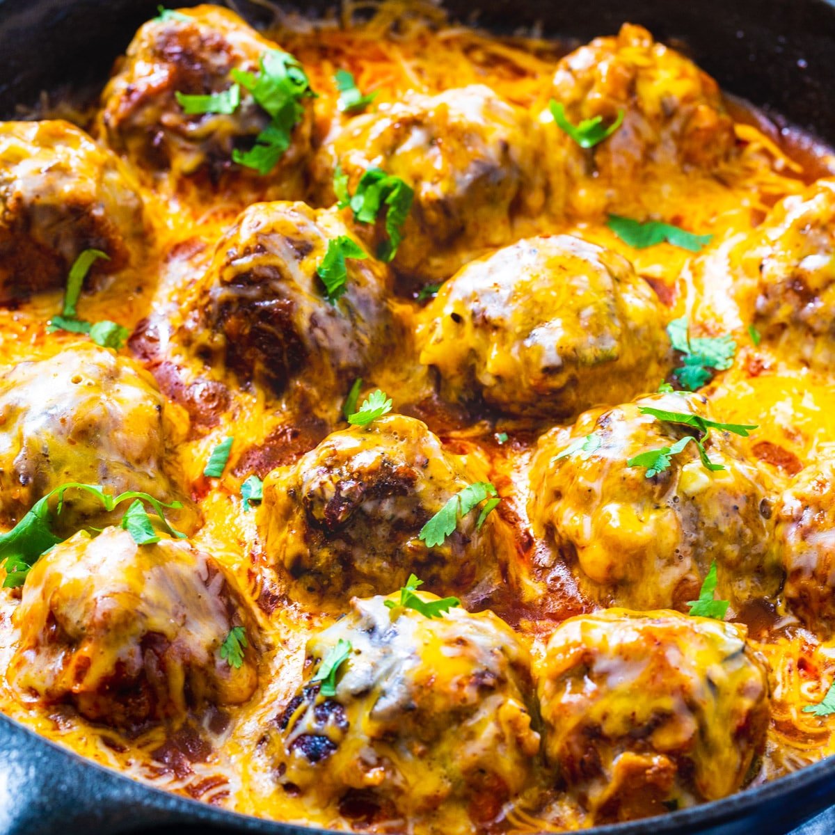 Tex Mex Meatballs coated with cheese in skillet.