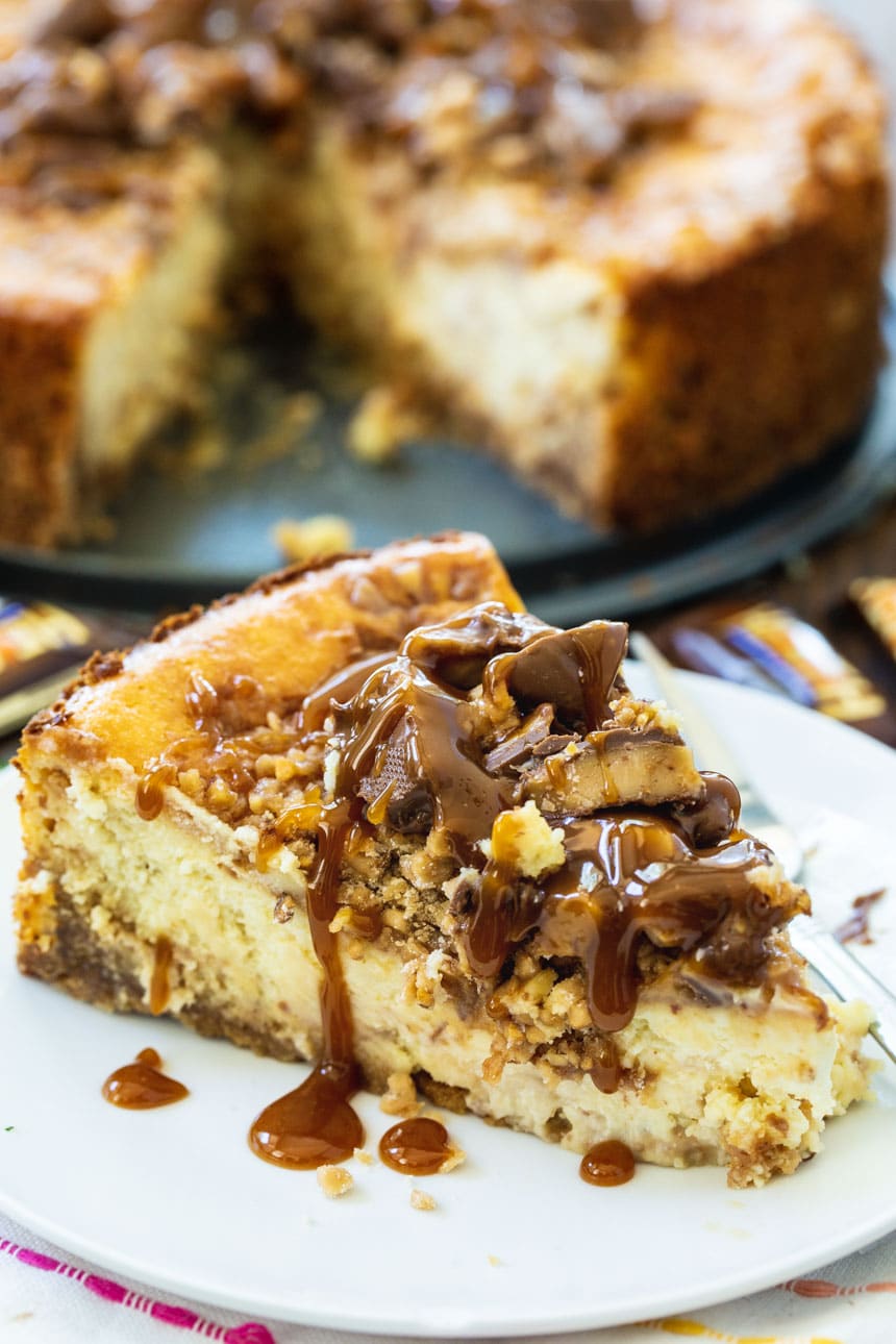 slice of Toffee Cheesecake with whole cheesecake in the background.