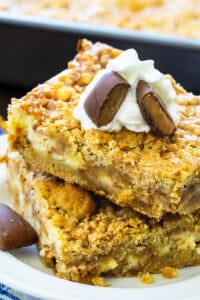 Two Toffee Cheesecake Bars stacked on a plate.
