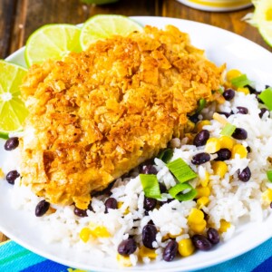 Tortilla Crusted Chicken with beans and rice on a white plate.