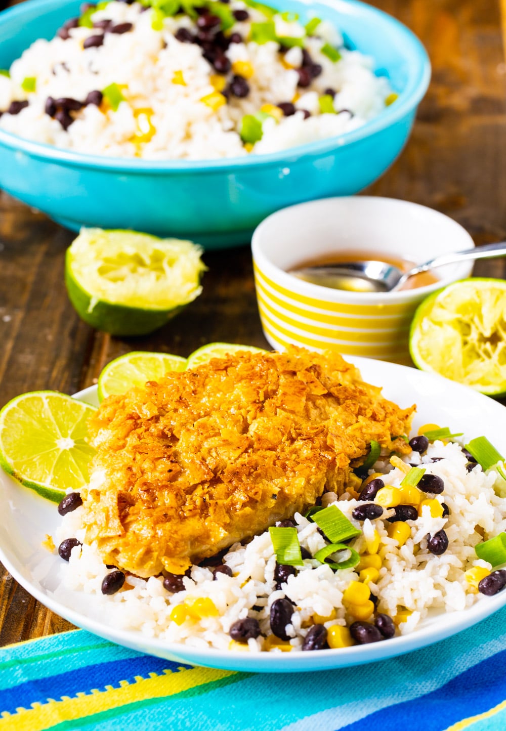 Chicken and rice on a plate with blowl of rice in background.