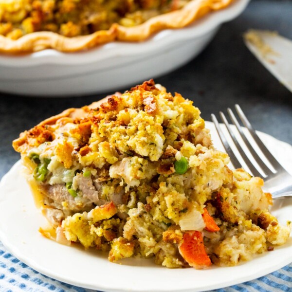 A slice of turkey pot pie served on a plate with a fork