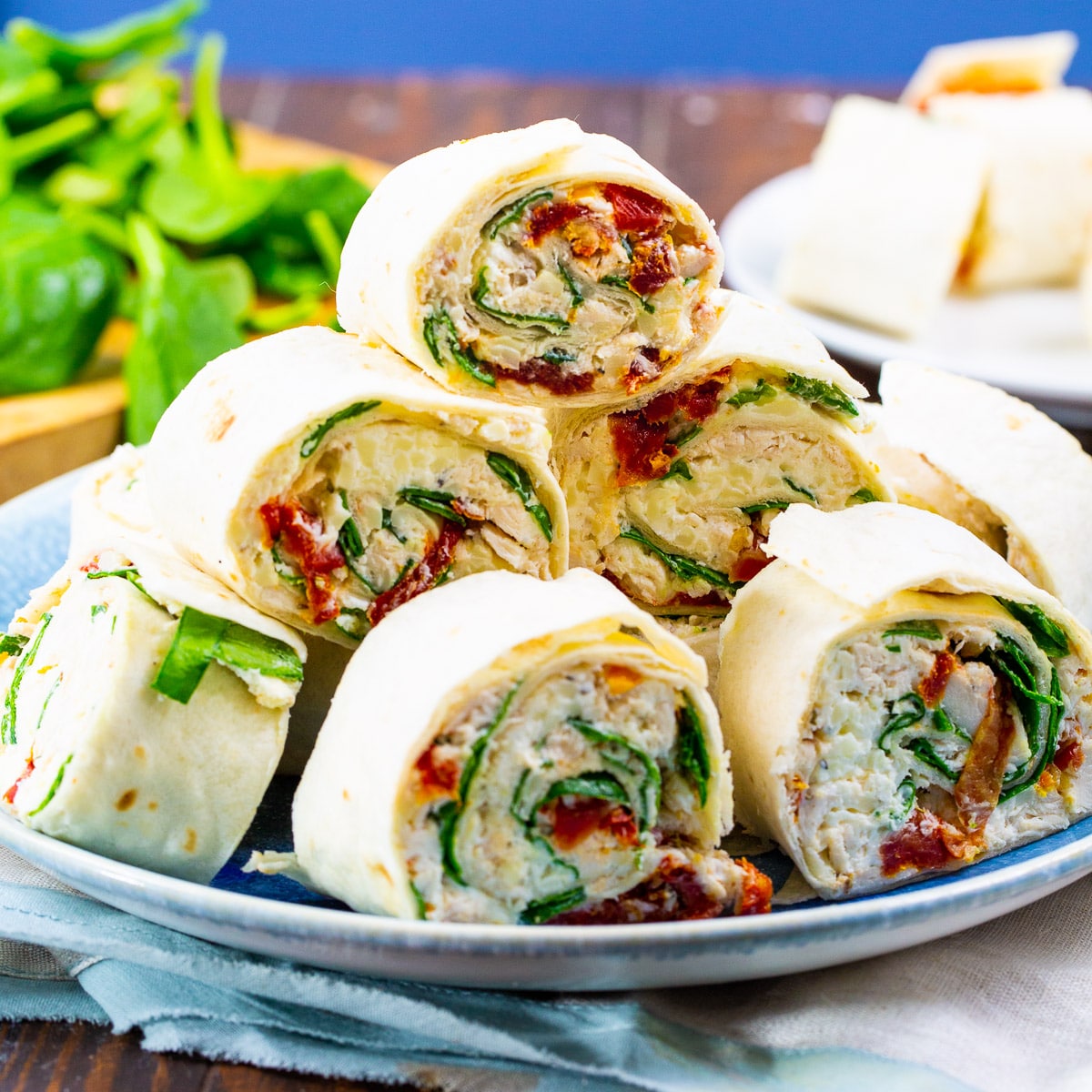 Tuscan Chicken Pinwheels piled up on a plate.