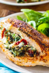 Tuscan Stuffed Chicken on a plate with salad.