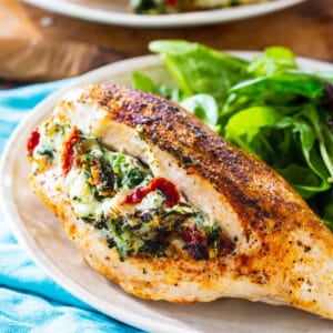 Tuscan Stuffed Chicken on a plate with salad.