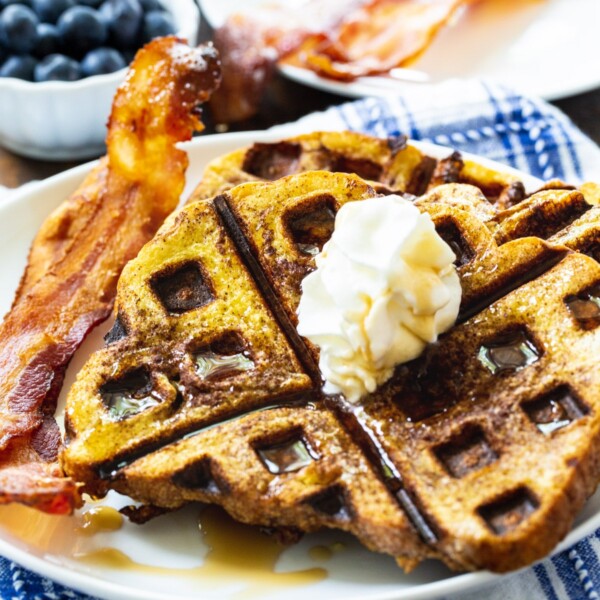 Waffled French Toast on a plate with bacon.