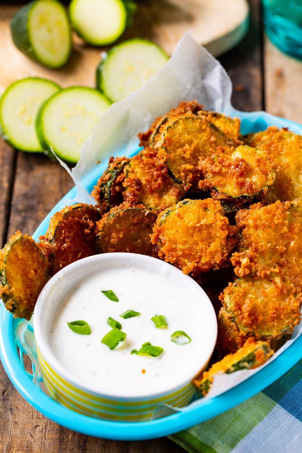 Fried Zucchini Chips in a basket with bowl of ranch dressing.