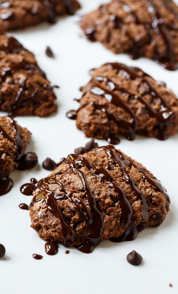 Chocolate Applesauce Scones with chocolate glaze on a white surface.