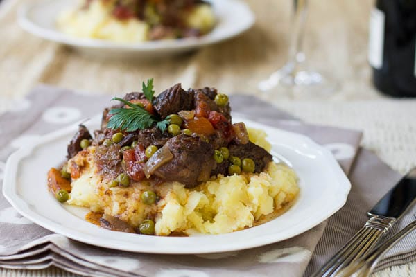 Beef Daube over mashed potatoes on a plate.