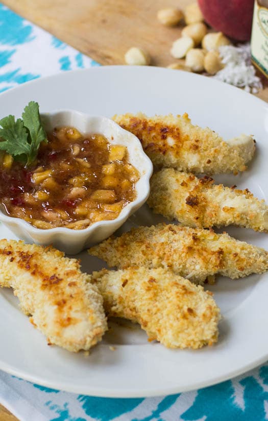 Coconut Macadamia Chicken Fingers on a white plate with dipping sauce.