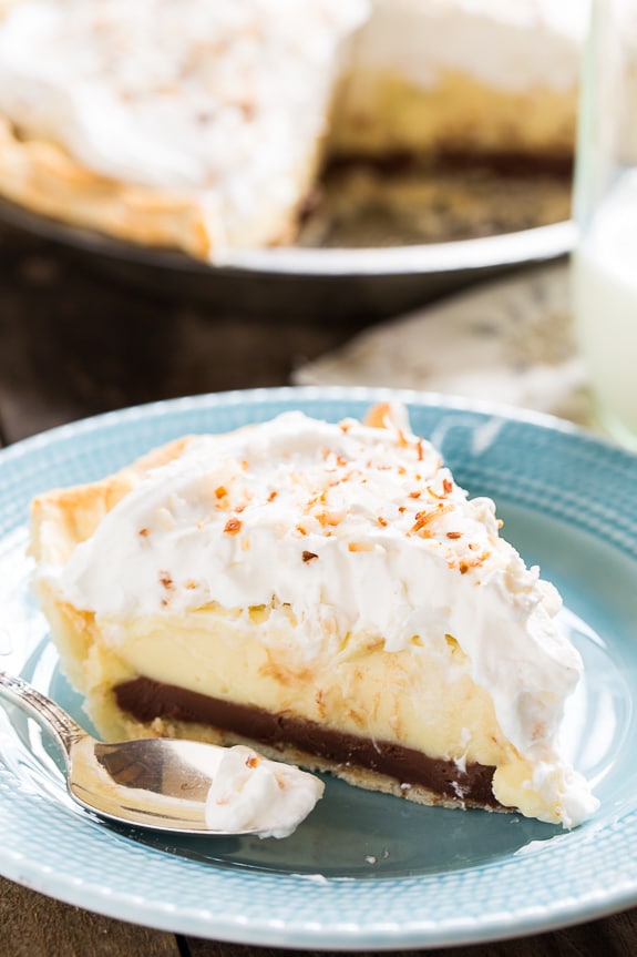 Black Bottom Coconut Cream Pie topped with whipped cream and toasted coconut.