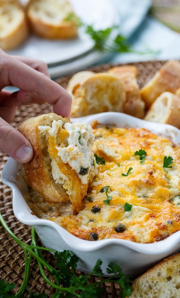 Incredible Hot Crab Dip made with cream cheese, mayo, crab meat, horseradish, capers, and cheddar cheese.
