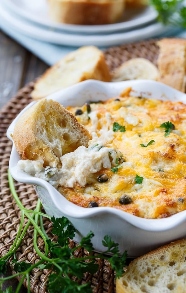 Incredible Hot Crab Dip made with crab meat, cream cheese, mayo, horseradish, capers, and cheddar cheese.