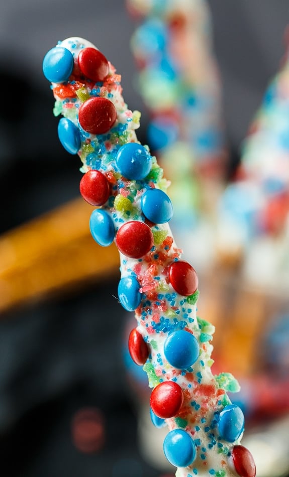 Firecracker Pretzel Rods for the 4th of July. Covered in red and blue mini M&Ms and Pop Rocks candy.