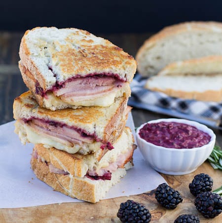 Panini slices stacked up with blackberries scattered.
