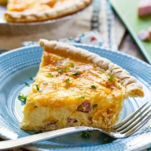 Easy Ham and Cheese Quiche slice on a blue plate.