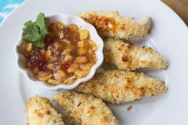 Macadamia Coconut Chicken Tenders on a plate with dipping sauce.
