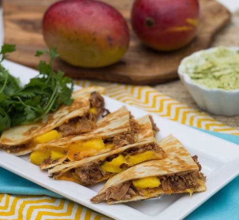 Barbecue Pork and Mango Quesadilla with mangos in background.