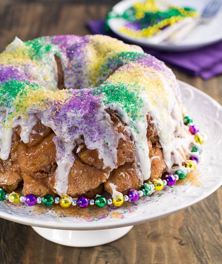 Mardi Gras Monkey Bread on cake stand decorated with beads.