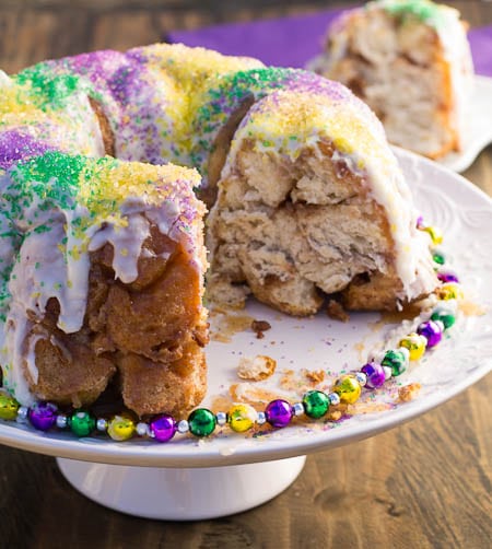 Mardi Gras Monkey Bread covered in sprinkles with piece cut out.