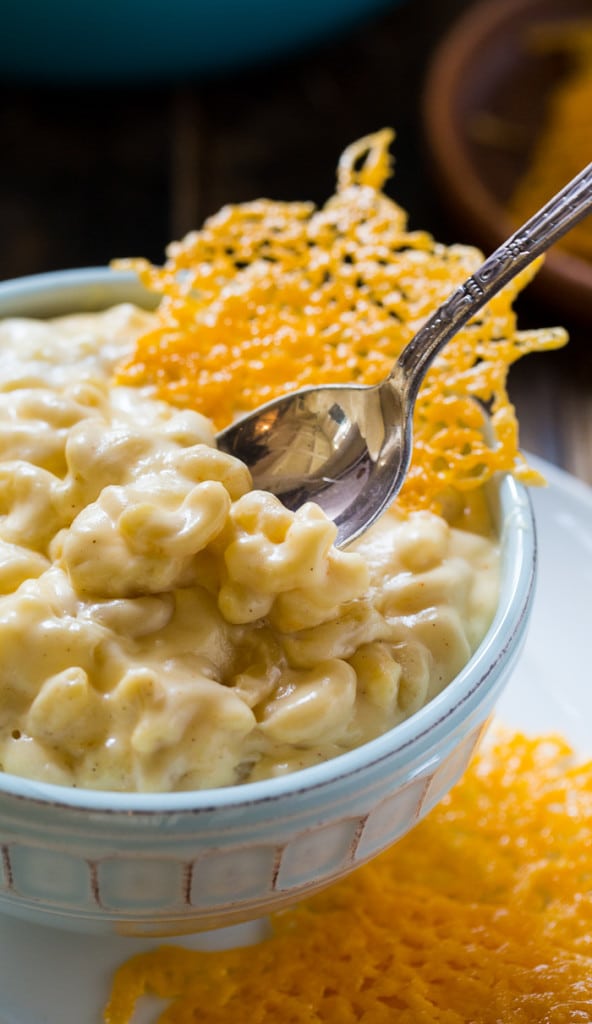 A spoon scooping up some mac and cheese from a bowl.