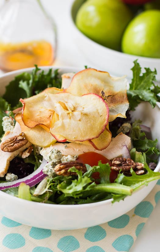 Cloes-up de la salade avec des chips de pomme sur le dessus.