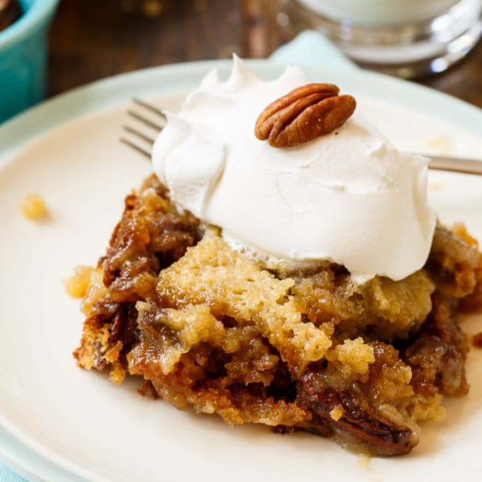 Slice of Pecan Pie Cake topped with vanilla ice cream.