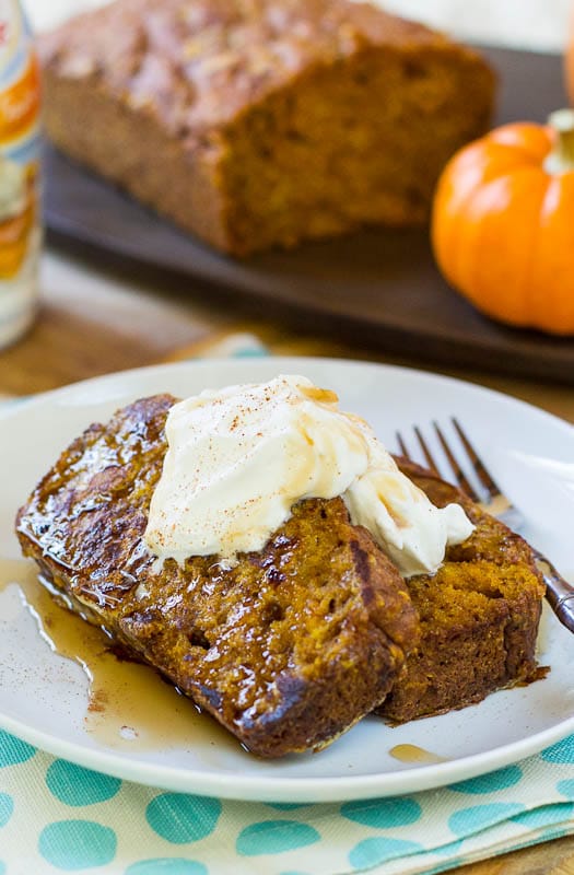 French Toast on a plate with loaf of pumpkin bread in background.