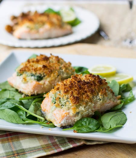 Two pieces of Baked Salmon on a square plate.