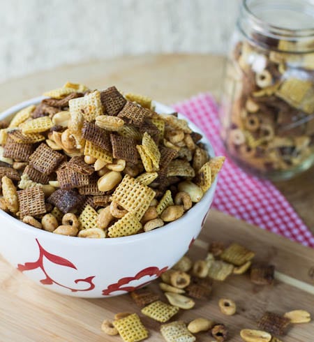 Spicy Snack Mix in a bowl with some loose snack mix surrounding it.